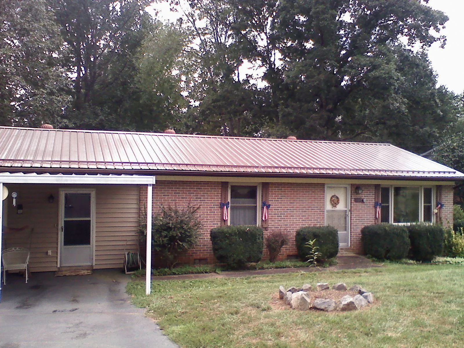 Bronze metal roof and carport on a brick ranch home — Roof Repair work by our crew in Firth